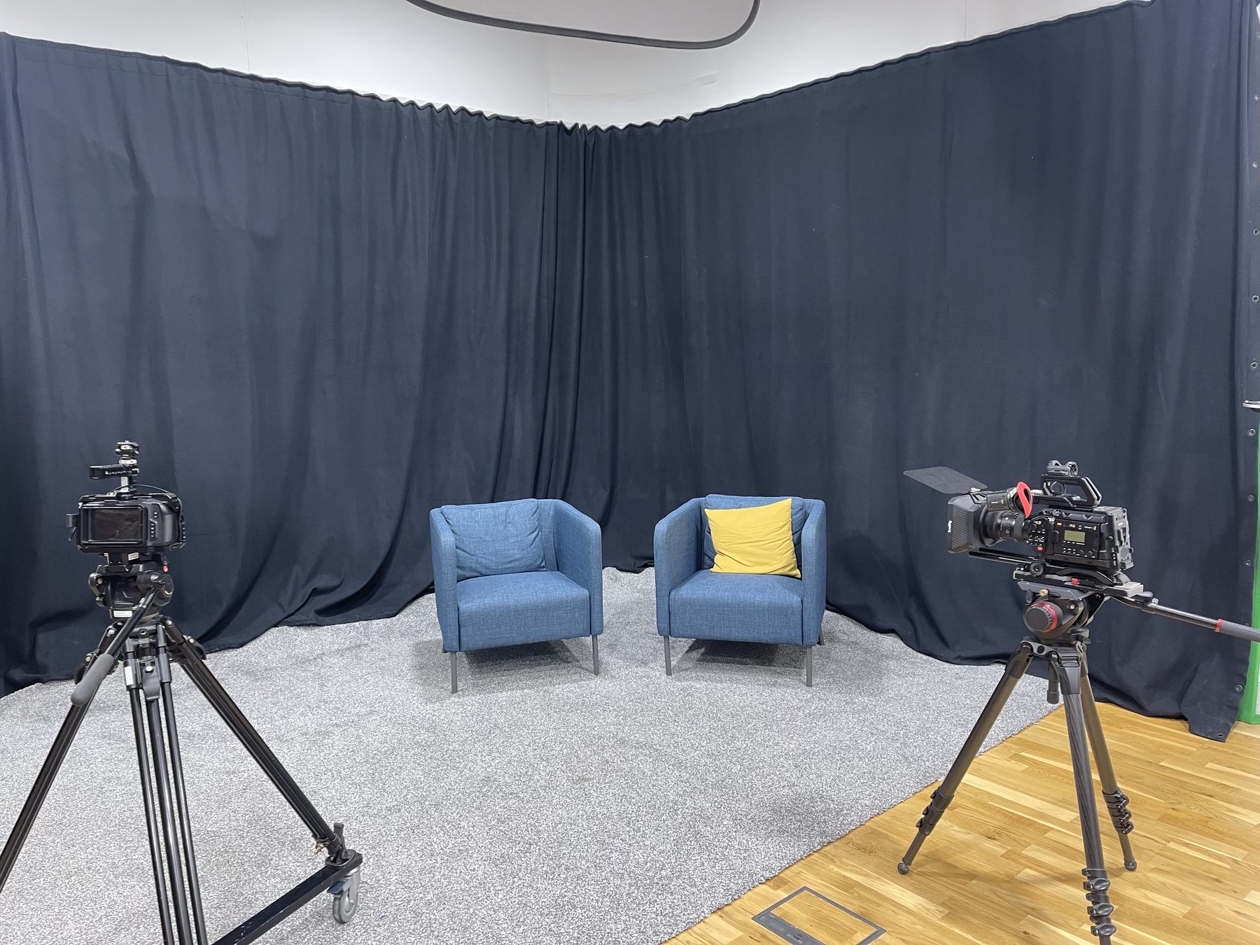 Interview set with two armchairs against a blackout curtain backdrop in Studio One