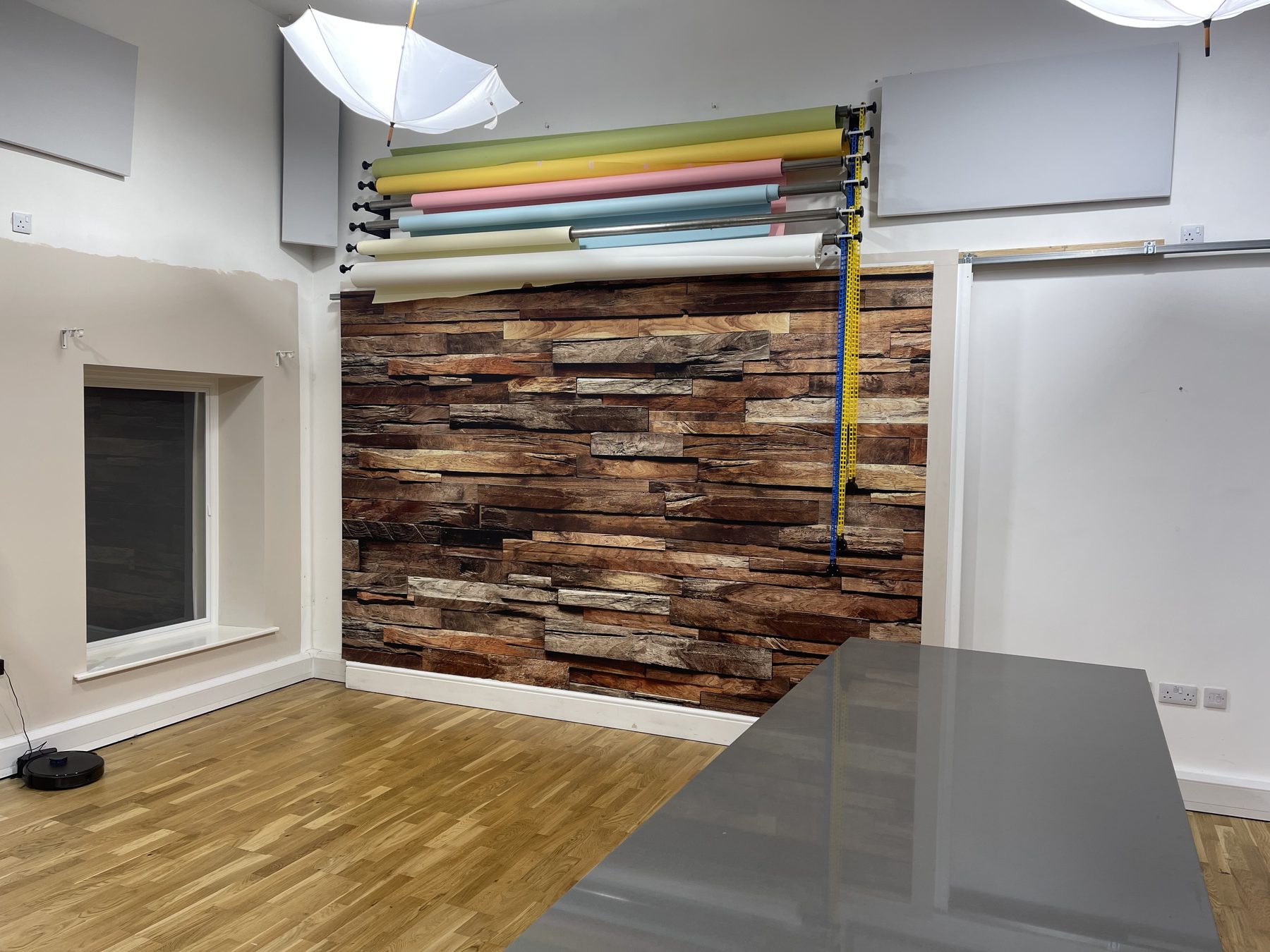 Wide view of the rustic reclaimed wood wall and studio floor in Studio One