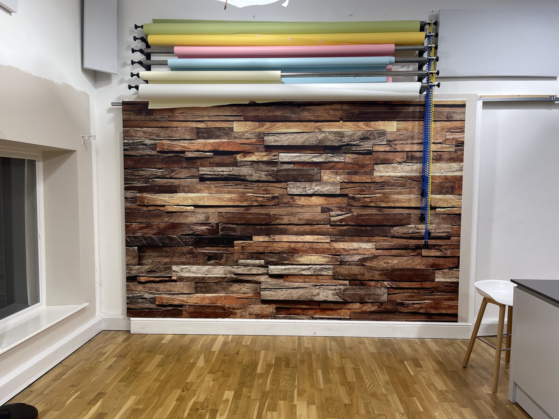 Reclaimed rustic wood feature wall in Studio One with paper backdrop rollers above