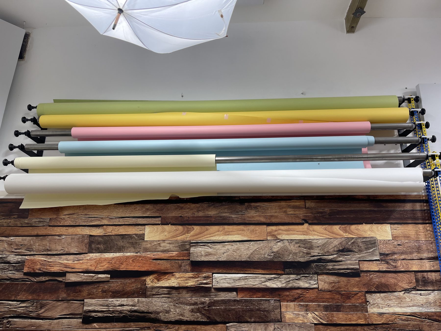 Six interchangeable coloured paper backdrop rolls mounted on an overhead rail in Studio Two